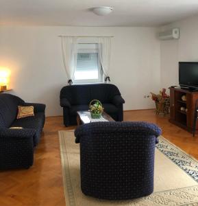 ein Wohnzimmer mit 2 Stühlen und einem Tisch in der Unterkunft Casa di Zanjic in Luštica