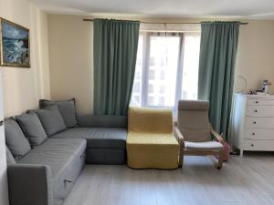 a living room with a couch and a chair at Apartments Pomorie Tundzha 9 in Pomorie +1 photo