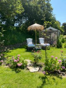 a garden with two chairs and a gazebo at Gastenverblijf nature 4-persoons in Ouddorp