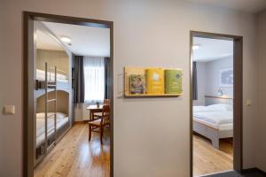 Habitación con espejo y dormitorio con cama. en JUFA Hotel Eisenerzer Ramsau en Eisenerz