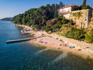 a beach with a group of people on the water at Apartman Dora in Rab