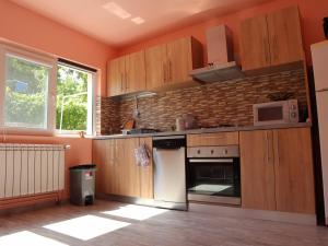 uma cozinha com armários de madeira e um forno branco em Casa Ili em Breaza
