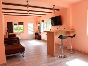 uma sala de estar com paredes cor de laranja e uma televisão em Casa Ili em Breaza