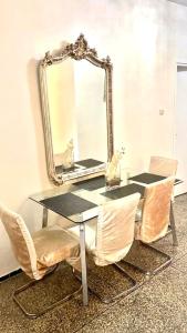 een tafel met stoelen en een spiegel aan een muur bij Popular, Central & Cheap in Rabat
