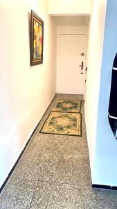 een hal met een witte deur en een tapijt bij Popular, Central & Cheap in Rabat