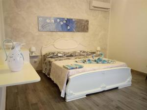 una camera con un letto bianco e un tavolo di Il Mandorlo a Platamona