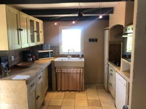 a kitchen with a sink and a window at Maison de Campagne in Sarragia