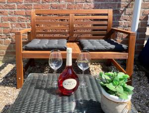 a bottle of wine sitting on a table with two wine glasses at Lise's Place in Vrouwenpolder
