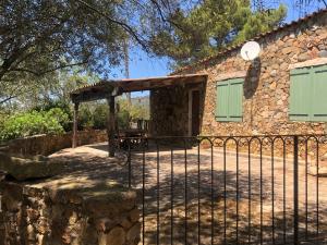 a stone house with a gate and a fence at Maison de Campagne in Sarragia