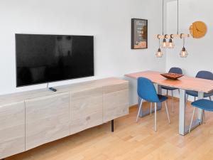 ein Esszimmer mit einem Tisch und einem TV auf einer Kommode in der Unterkunft ARISER - Mountain View Business Apartment in Zug