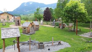 einen Spielplatz mit Holzspielstrukturen in einem Park in der Unterkunft Haus Felder Schoppernau in Schoppernau