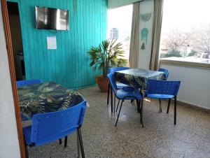 Habitación con mesa, sillas y pared azul. en Residencial Ariand en Santa Rosa de Calamuchita