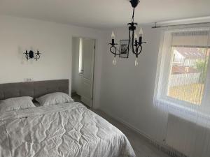 ein weißes Schlafzimmer mit einem Bett und einem Fenster in der Unterkunft Casa Andreea in Sînmartin