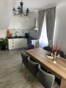 eine Küche mit einem Holztisch mit Stühlen und einem Esszimmer in der Unterkunft Casa Andreea in Sînmartin