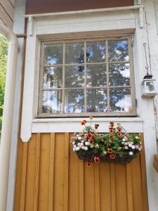 een raam op een houten deur met een pot bloemen bij Rauhaa, hyvää unta maaseudulla in Loppi