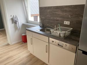 a kitchen with a sink and a counter top at Moderne Ferienwohnung Hergolshausen in Waigolshausen +11 photos