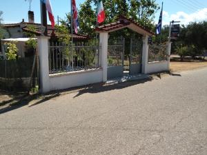 una valla con banderas al costado de una carretera en KILLINI COTTAGE STUDIO the small cyclades en Kyllíni