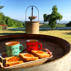 deux tasses à café et des tranches de pain sur une assiette dans l'établissement Podere Baratta agriturismo e cantina, à Collinello
