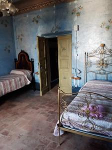 1 dormitorio con 2 camas y paredes azules en Palazzo Tuemi, en Castelplanio