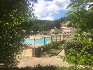 ein Pool mit Sonnenschirmen in einem Resort in der Unterkunft Odalys , hauts de Salavas in Salavas
