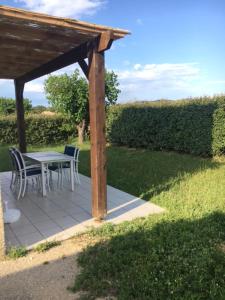 eine Terrasse mit einem Tisch und Stühlen unter einem Pavillon in der Unterkunft Odalys , hauts de Salavas in Salavas