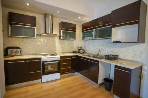 uma cozinha com armários castanhos e electrodomésticos brancos em Irini's sea view apartment 145m2 Nea Michaniona em Michaniona