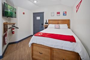 a bedroom with a bed with a red blanket at The Dorm Hotel in Ithaca