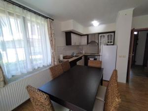 a kitchen with a black table and chairs in a room at Вила Магдалена, к-с Александриа in Dobrinishte +8 photos