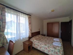 1 dormitorio con cama y ventana grande en Вила Магдалена, к-с Александриа en Dobrinishte