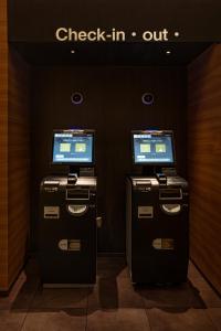 two atm machines in a room with a check in sign at Hotel Xcell 広島 流川通り in Hiroshima
