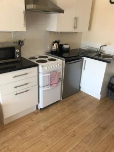 a kitchen with a stove top oven and a refrigerator at Nook and Harbour Holiday Apartments & rooms in Weston-super-Mare