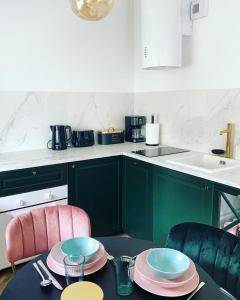 a kitchen with a table with plates on it at Apartament Tsuru in Dziwnówek