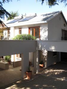 a white house with a porch with plants in it at Craighall Executive Suites in Johannesburg