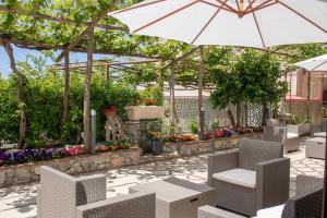 patio con sedie, ombrellone e fiori di Il Cortiletto ad Agerola
