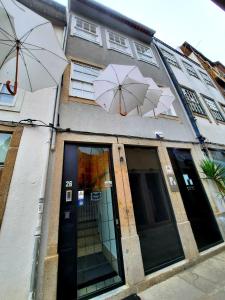 a building with umbrellas on the side of it at Souto Guest House in Braga