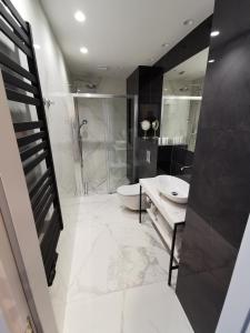 a bathroom with a shower and a toilet and a sink at Apartament Międzyzdroje 006 w Maritime Residence in Międzyzdroje