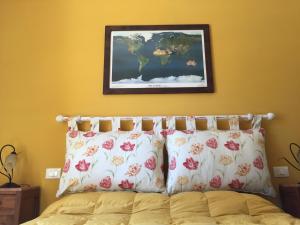 a bed with two pillows and a picture on the wall at Attico con Terrazza panoramica - LAKEHOLIDAY IT in Castel di Tora