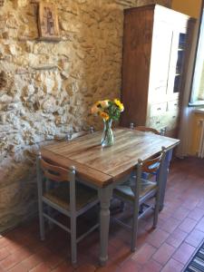 a wooden table with a vase of flowers on it at Attico con Terrazza panoramica vista lago - LAKEHOLIDAY IT in Castel di Tora