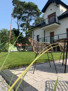 a chair sitting on a sidewalk in front of a house at Na Wczasowej - Apartamenty in Międzywodzie