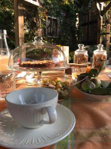 a table with a cup and a bowl of fruit at MAMOTA B&B in Vesime
