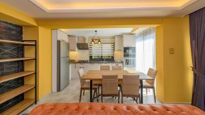 cocina y comedor con paredes amarillas, mesa y sillas en Söğüt 1 - 4 Bedroom with jacuzzi in Fethiye, en Fethiye