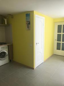 een kamer met een wasmachine en een witte deur bij Dārza māja in Liepāja