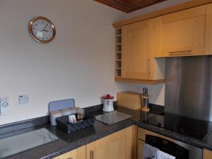 a kitchen with a clock on the wall and a counter at Riverside in Tarbert