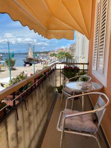 a balcony with a table and chairs and a view of the water at Studio Apartment Naya in Mali Lošinj