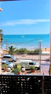 uma vista para uma praia com carros estacionados num parque de estacionamento em Appartamento Lungomare 20 mt dal mare em Crotone
