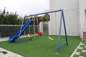 a playground with two swings on a lawn at استراحة لؤلؤة الجبل in Sayq