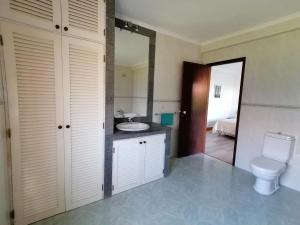 a bathroom with a toilet and a sink at Quinta do Areeiro in Horta