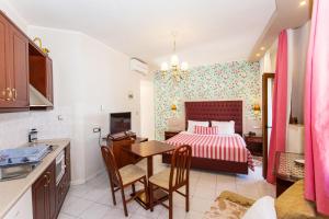 a kitchen and a bedroom with a bed and a table at Olympic Apartments in Parga