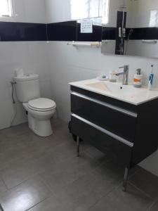 a bathroom with a toilet and a sink at bienvenue a la maison in Sainte-Marie