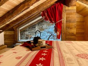 een slaapkamer met een bed met een rode deken bij Le Relais du Boucher in Gaby